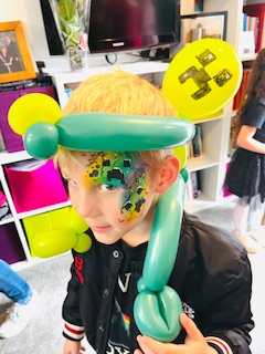 Boy with minecraft face paint and minecraft balloon hat in Stafford